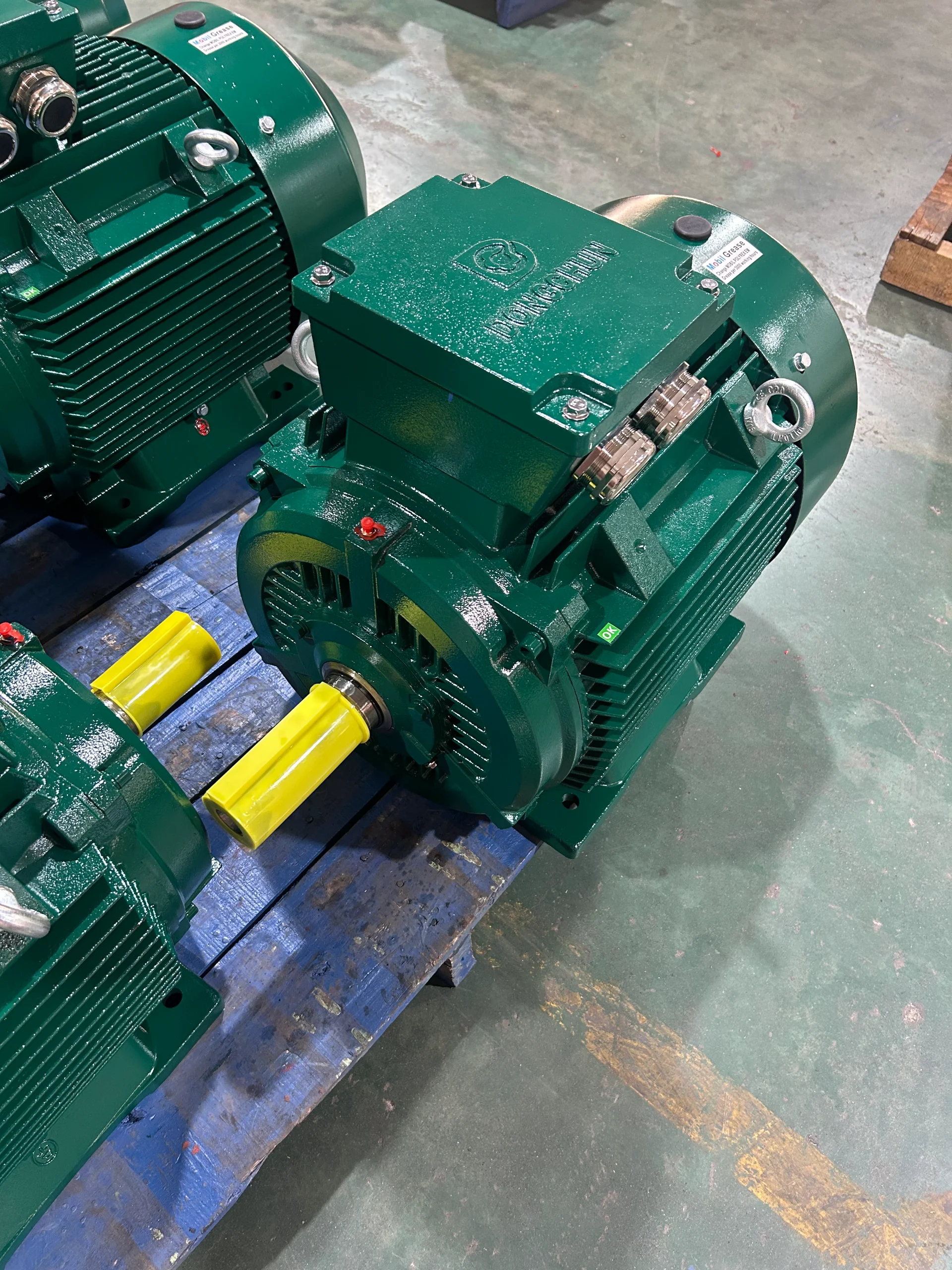 Quality inspector checking electric motor parameters on production line in Chinese factory Inspector examining electric motor quality on a factory production line